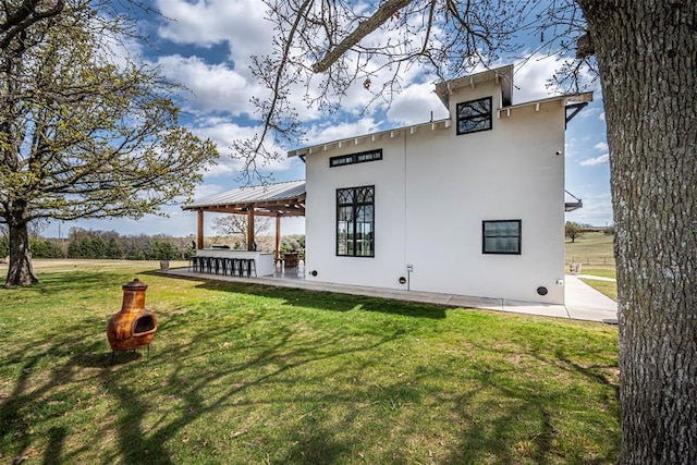 18800 NE 122nd St, Jones, OK 73049 - view of side of home with a yard, a gazebo, stucco siding, and a patio