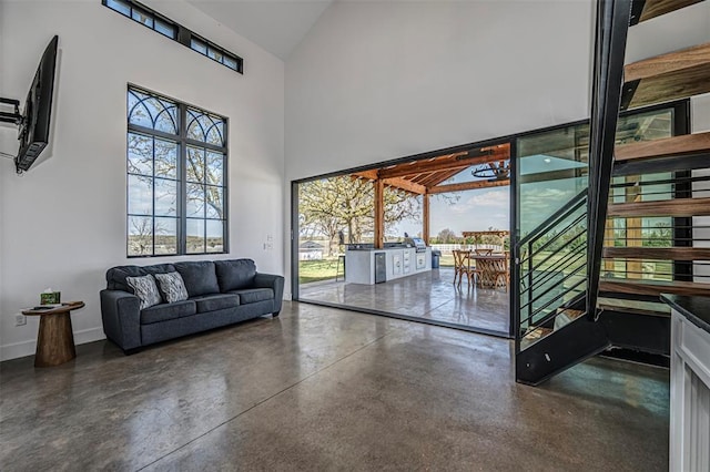 18800 NE 122nd St, Jones, OK 73049 - doorway to outside featuring concrete flooring, healthy amount of natural light, high vaulted ceiling, baseboards, and stairs