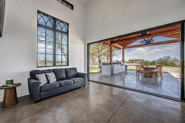 18800 NE 122nd St, Jones, OK 73049 - living room with concrete flooring, a towering ceiling, and baseboards