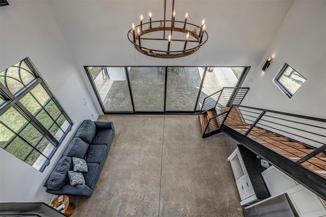18800 NE 122nd St, Jones, OK 73049 - unfurnished living room with a chandelier, a high ceiling, and concrete flooring