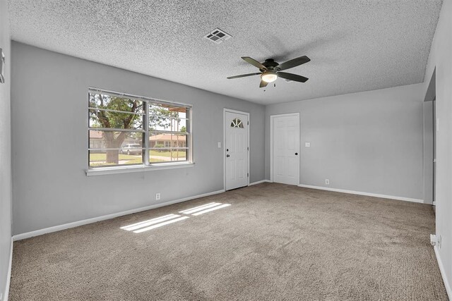 1036 Box St, Altus, OK 73521 - unfurnished room featuring ceiling fan, carpet, baseboards, and a textured ceiling
