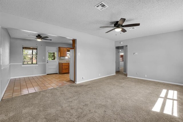 1036 Box St, Altus, OK 73521 - spare room featuring ceiling fan, a textured ceiling, light carpet, light tile patterned flooring, and baseboards