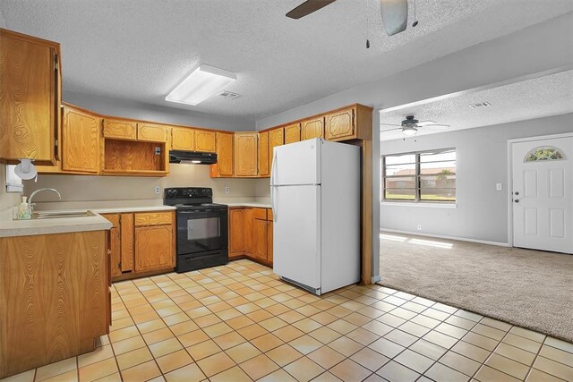 1036 Box St, Altus, OK 73521 - kitchen with freestanding refrigerator, black range with electric stovetop, under cabinet range hood, ceiling fan, and a textured ceiling