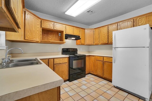 1036 Box St, Altus, OK 73521 - kitchen featuring freestanding refrigerator, black range with electric cooktop, a sink, under cabinet range hood, and a textured ceiling