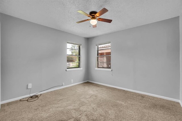 1036 Box St, Altus, OK 73521 - unfurnished room featuring a textured ceiling, a ceiling fan, carpet floors, and baseboards