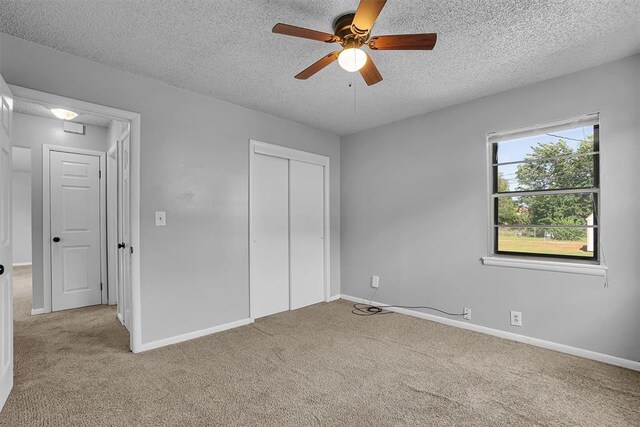 1036 Box St, Altus, OK 73521 - unfurnished bedroom with carpet, a textured ceiling, a closet, baseboards, and a ceiling fan