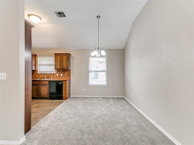 19901 Adagio Ln, Edmond, OK 73012 - kitchen featuring black dishwasher, a chandelier, healthy amount of natural light, light colored carpet, and vaulted ceiling