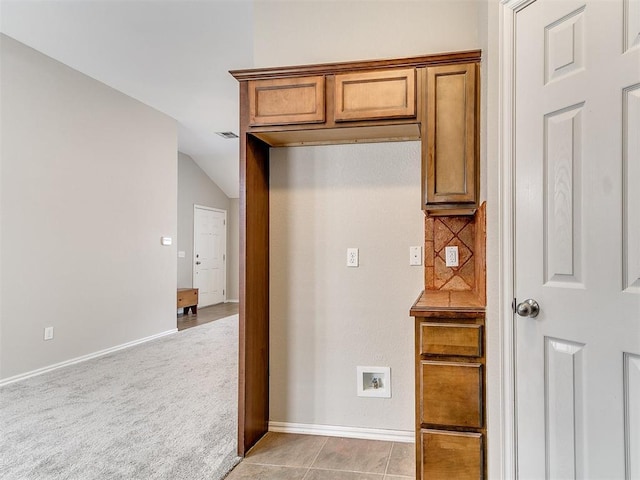 19901 Adagio Ln, Edmond, OK 73012 - kitchen with brown cabinets, lofted ceiling, baseboards, and light colored carpet