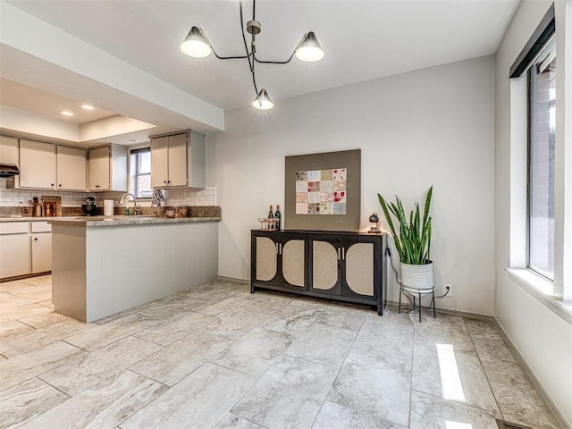 13613 Pin Oak, Edmond, OK 73013 - kitchen with tasteful backsplash, a peninsula, decorative light fixtures, and exhaust hood