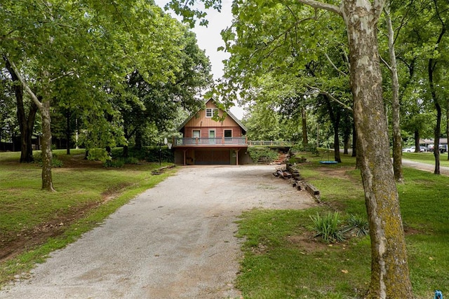 1000 N Canadian Ave, Purcell, OK 73080 - chalet / cabin featuring driveway, a wooden deck, a front lawn, and an attached garage