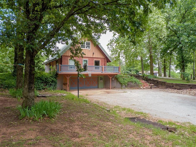 1000 N Canadian Ave, Purcell, OK 73080 - log cabin with driveway, a deck, an attached garage, log siding, and board and batten siding