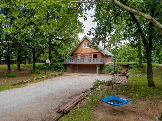 1000 N Canadian Ave, Purcell, OK 73080 - view of front of home with driveway, a wooden deck, board and batten siding, and a garage
