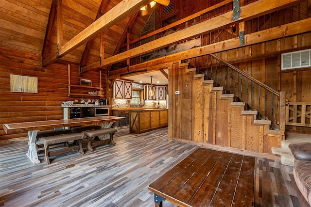 1000 N Canadian Ave, Purcell, OK 73080 - unfurnished dining area with dark wood-style flooring, wood walls, stairway, wood ceiling with exposed beams, and high vaulted ceiling
