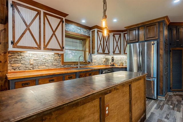 1000 N Canadian Ave, Purcell, OK 73080 - kitchen featuring freestanding refrigerator, a sink, wooden counters, dark wood-style flooring, and tasteful backsplash