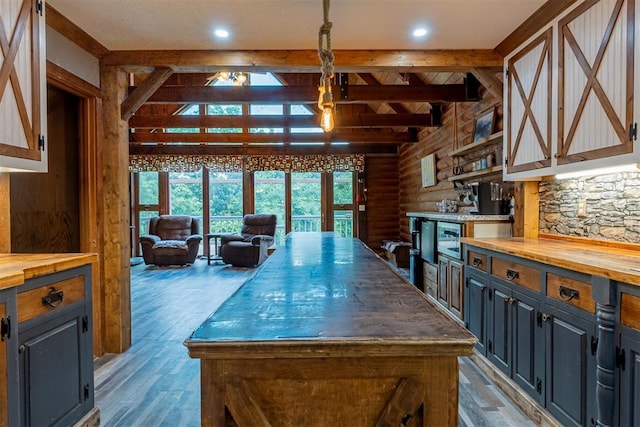 1000 N Canadian Ave, Purcell, OK 73080 - kitchen featuring wooden counters, rustic walls, light wood-style floors, a kitchen island, and pendant lighting