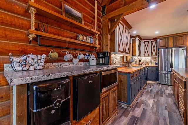 1000 N Canadian Ave, Purcell, OK 73080 - kitchen with appliances with stainless steel finishes, dark wood-style flooring, a sink, tasteful backsplash, and open shelves