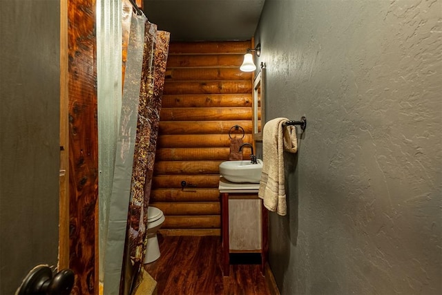 1000 N Canadian Ave, Purcell, OK 73080 - full bathroom with log walls, wood finished floors, vanity, and toilet