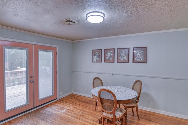 912 E Comanche St, Norman, OK 73071 - dining space featuring french doors, ornamental molding, wood finished floors, a textured ceiling, and baseboards