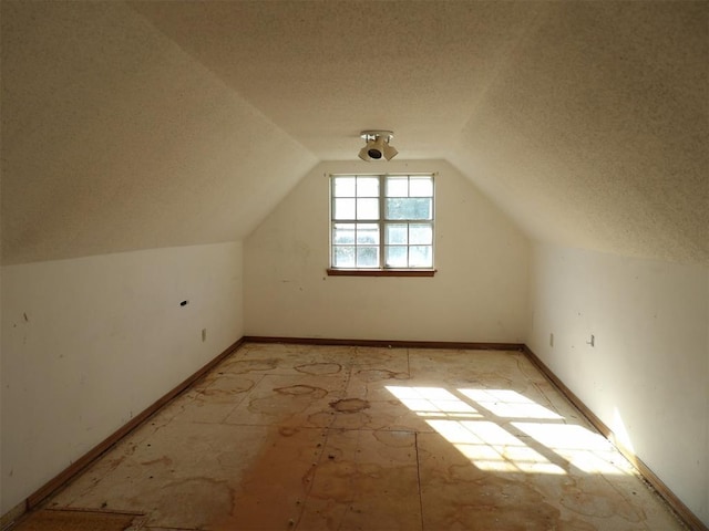 8317 NW 27th St, Bethany, OK 73008 - additional living space with a textured ceiling, vaulted ceiling, and baseboards