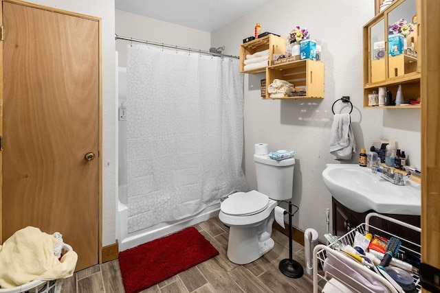 2645 E 2090th Rd, Hugo, OK 74743 - full bath featuring wood tiled floors, vanity, toilet, shower / bath combo with shower curtain, and baseboards