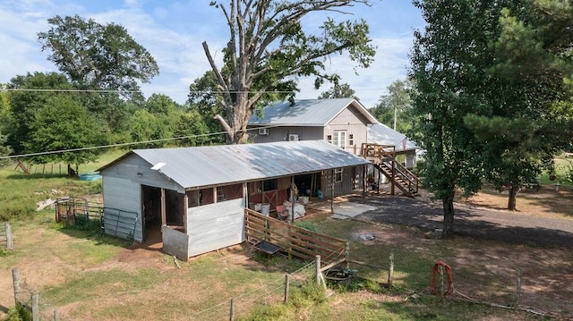 2645 E 2090th Rd, Hugo, OK 74743 - back of property featuring metal roof, an exterior structure, stairway, an outdoor structure, and a wooden deck
