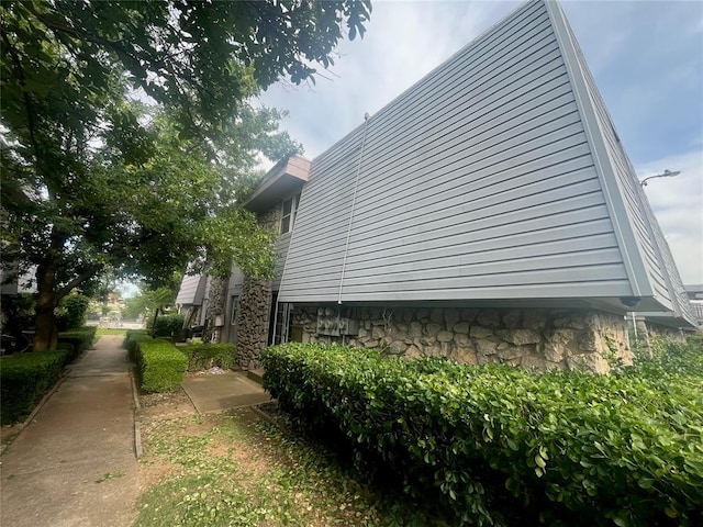 view of side of home featuring stone siding