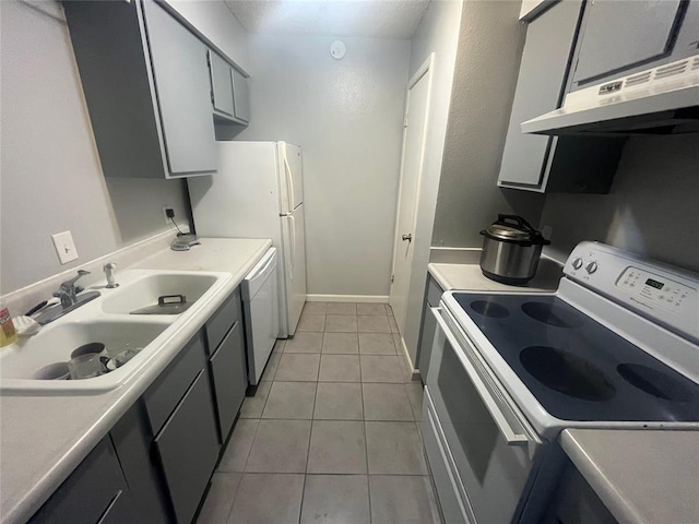 kitchen with white appliances, a sink, light tile patterned floors, light countertops, and range hood