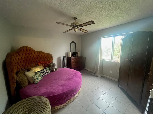 bedroom with light tile patterned floors, ceiling fan, baseboards, and a textured ceiling