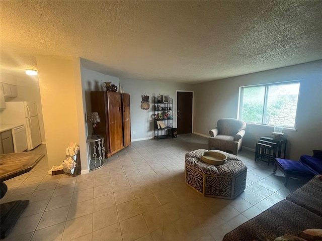 living room featuring a textured ceiling, light tile patterned floors, and baseboards