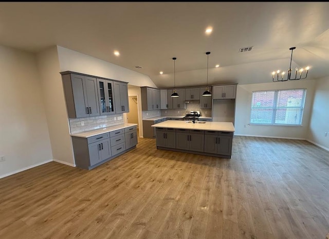 5000 SE 85th St, Oklahoma City, OK 73135 - kitchen featuring gray cabinetry, vaulted ceiling, a sink, light wood finished floors, and tasteful backsplash