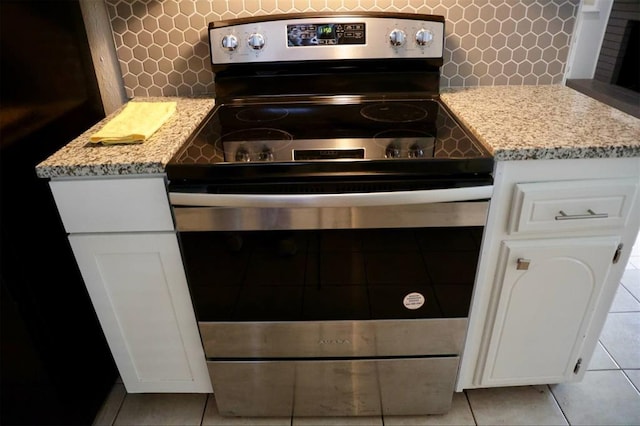 3012 SE 55th St, Oklahoma City, OK 73135 - kitchen with electric stove, light tile patterned floors, decorative backsplash, and white cabinetry