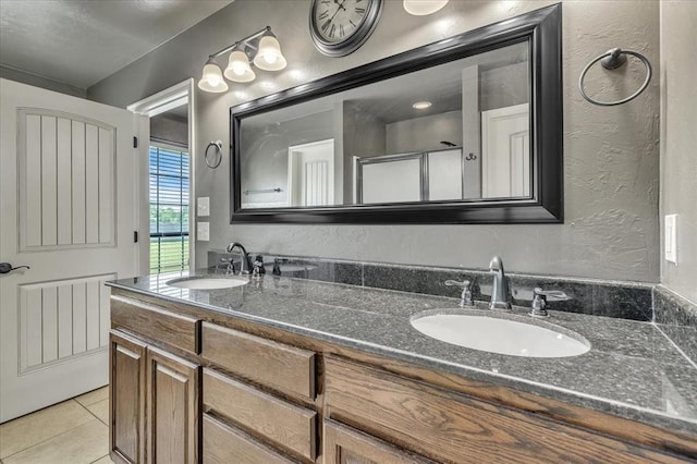 2900 Coventry Manor Dr, Oklahoma City, OK 73128 - full bath with double vanity, tile patterned flooring, a textured wall, and an enclosed shower