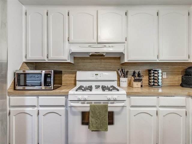 625 Jasmine Pl, Edmond, OK 73003 - kitchen featuring white gas range, under cabinet range hood, white cabinets, stainless steel microwave, and light countertops