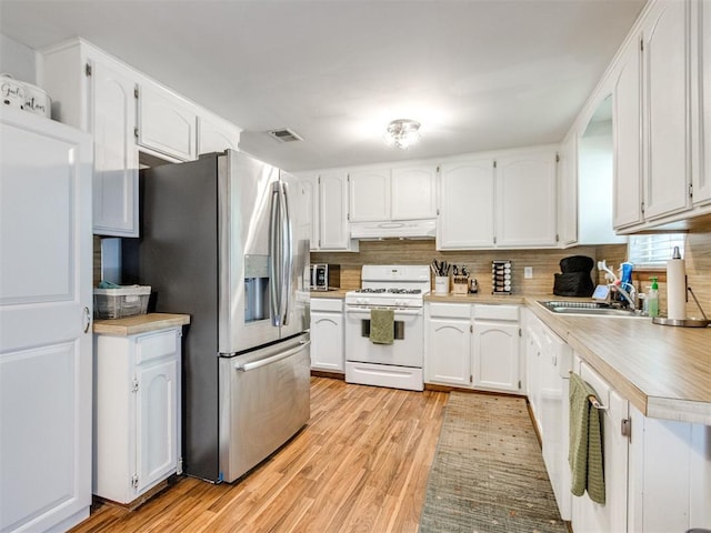 625 Jasmine Pl, Edmond, OK 73003 - kitchen with gas range gas stove, a sink, under cabinet range hood, stainless steel fridge with ice dispenser, and light countertops