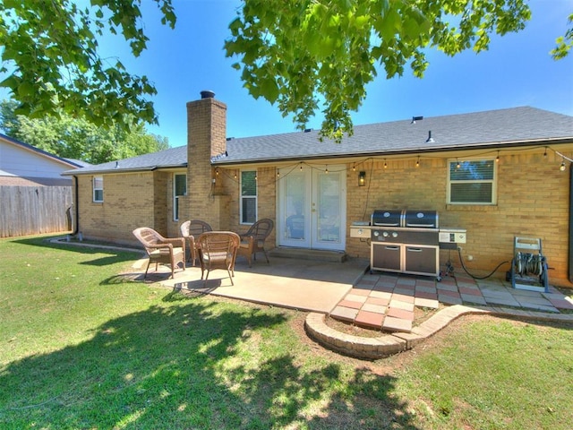 625 Jasmine Pl, Edmond, OK 73003 - back of property with a chimney, brick siding, a patio area, and french doors