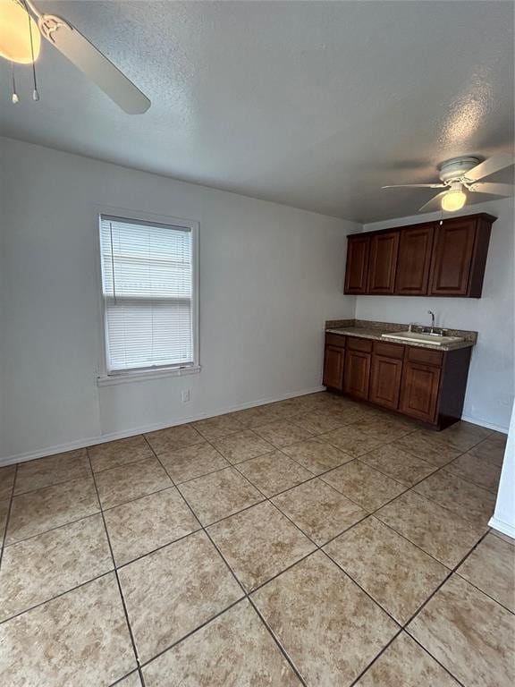 4404 N State St, Warr Acres, OK 73122 - kitchen with ceiling fan, a textured ceiling, light tile patterned flooring, baseboards, and light countertops