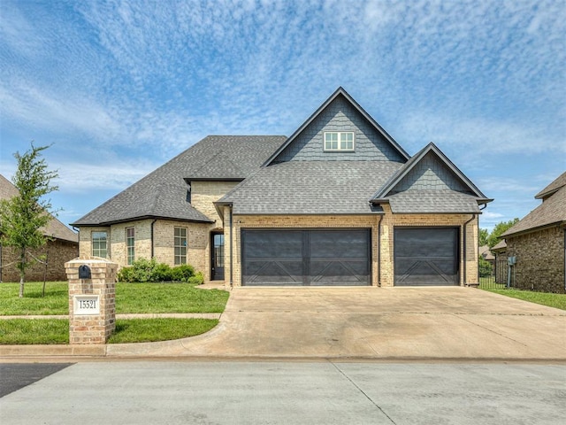 15521 Park Lake Ln, Edmond, OK 73013 - view of front of home with a shingled roof, brick siding, concrete driveway, and a garage