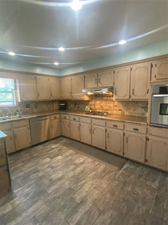 308 Jeffrey Laird Pl, Moore, OK 73160 - kitchen featuring stainless steel appliances, under cabinet range hood, dark wood-style floors, tasteful backsplash, and recessed lighting