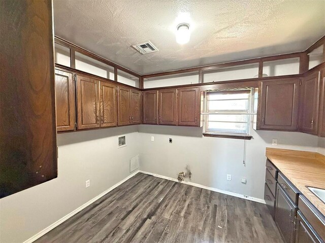 2405 S Mansfield St, Del City, OK 73115 - washroom with gas dryer hookup, washer hookup, hookup for an electric dryer, dark wood-style flooring, and a textured ceiling