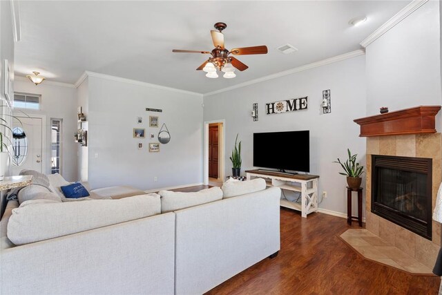 7713 Geneva Rea Ln, Yukon, OK 73099 - living room with ceiling fan, dark wood finished floors, crown molding, a tiled fireplace, and baseboards
