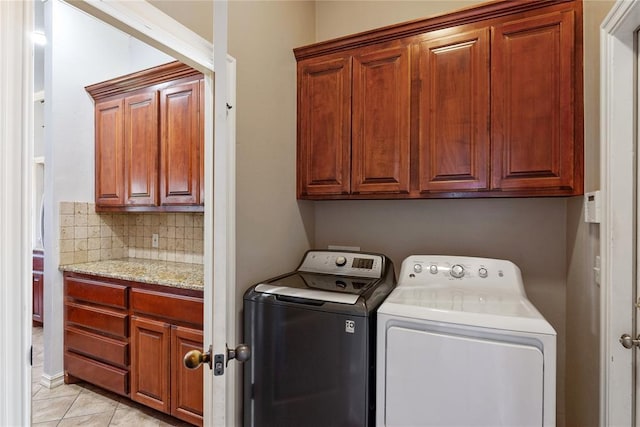 7713 Geneva Rea Ln, Yukon, OK 73099 - laundry area featuring independent washer and dryer, cabinet space, and light tile patterned floors