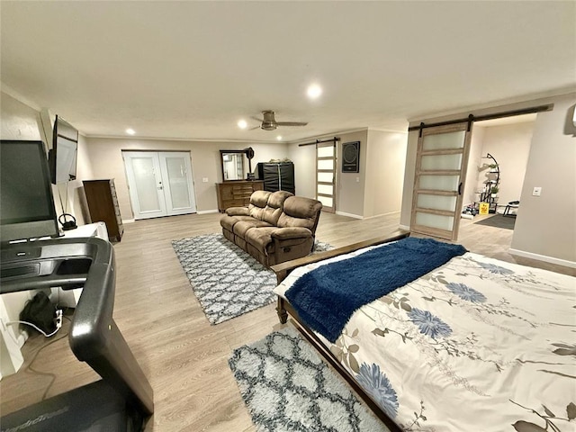 129 Park Dr, Sayre, OK 73662 - bedroom featuring a barn door, baseboards, light wood-type flooring, recessed lighting, and ceiling fan