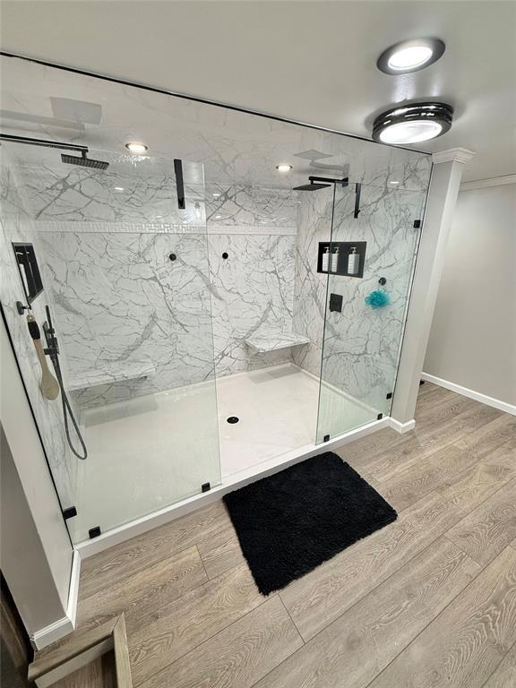 129 Park Dr, Sayre, OK 73662 - full bathroom featuring wood finished floors, a marble finish shower, baseboards, and crown molding
