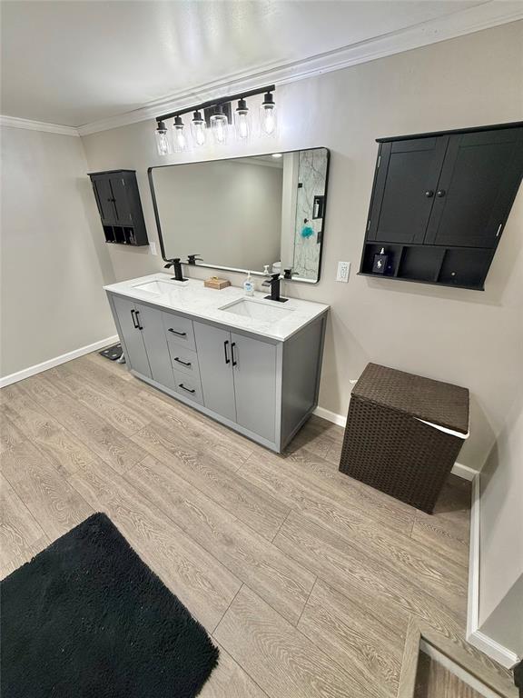129 Park Dr, Sayre, OK 73662 - full bathroom with wood finished floors, crown molding, double vanity, and baseboards
