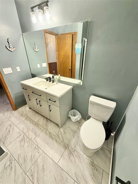 129 Park Dr, Sayre, OK 73662 - bathroom with marble finish flooring, vanity, and toilet