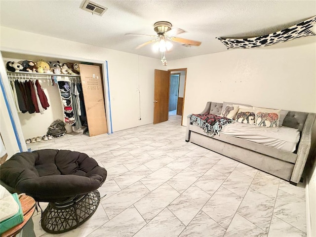 129 Park Dr, Sayre, OK 73662 - bedroom with marble look tiles, a closet, a textured ceiling, and ceiling fan