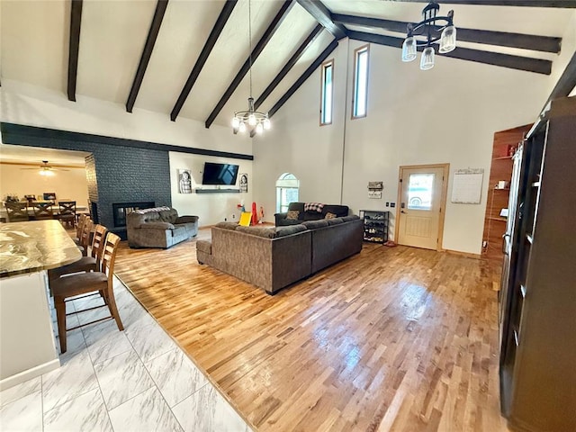 129 Park Dr, Sayre, OK 73662 - living room featuring high vaulted ceiling, beam ceiling, a chandelier, a fireplace, and ceiling fan