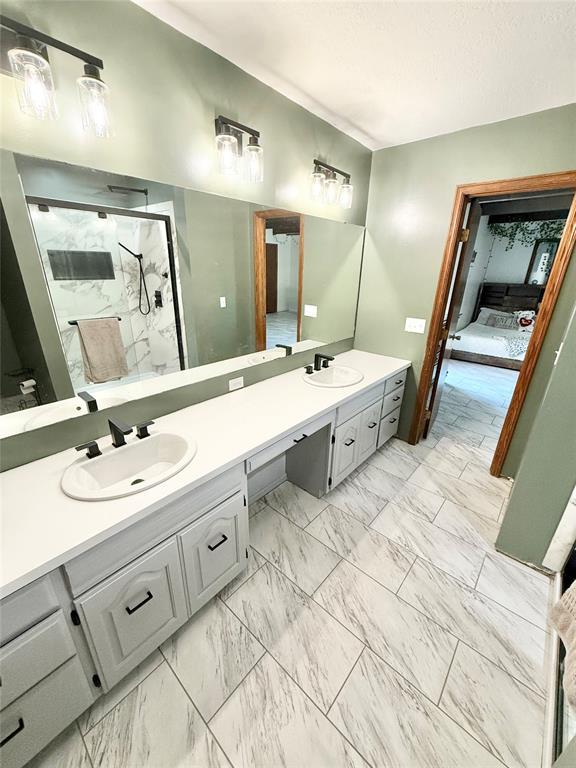 129 Park Dr, Sayre, OK 73662 - full bath featuring double vanity, marble finish flooring, and a marble finish shower