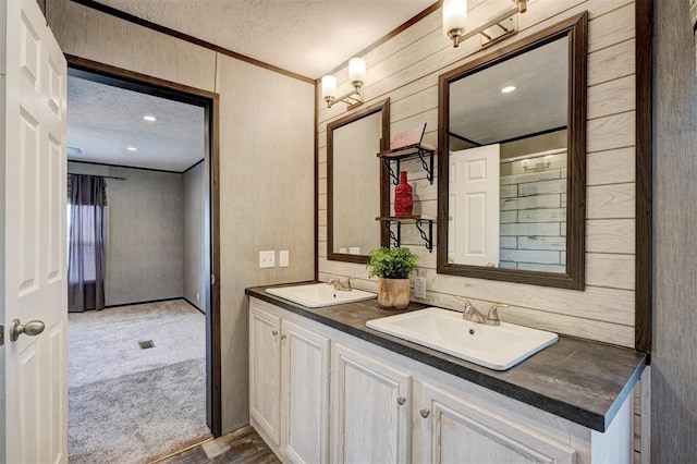 177074 Stephens Rd, Duncan, OK 73533 - bathroom with a textured ceiling, crown molding, double vanity, and wood finished floors