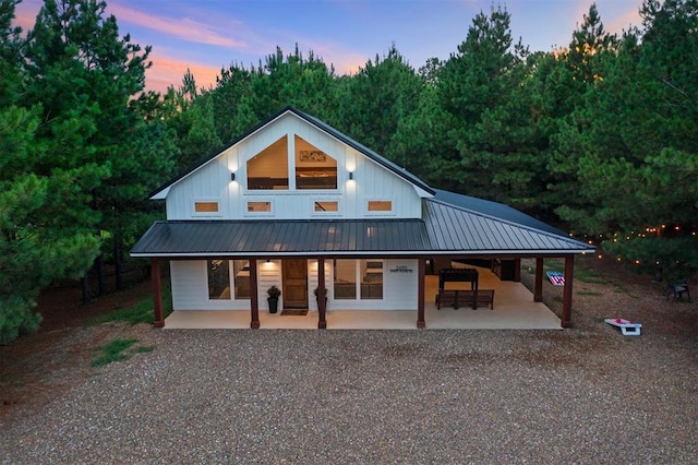2690 Sweet Home Rd, Broken Bow, OK 74728 - view of front facade with driveway, board and batten siding, a porch, and metal roof